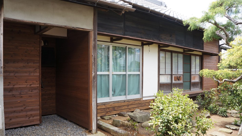 Design ideas for an expansive asian one-storey brown house exterior in Nagoya with wood siding, a gable roof and a tile roof.