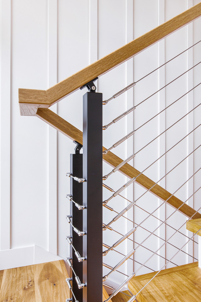 Foto de escalera en U marinera con escalones de madera, contrahuellas de madera, barandilla de madera y panelado