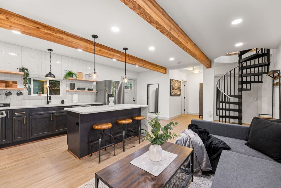 living room area with an open concept with the kitchen and bathroom, spiral staircase to the master bedroom upstairs