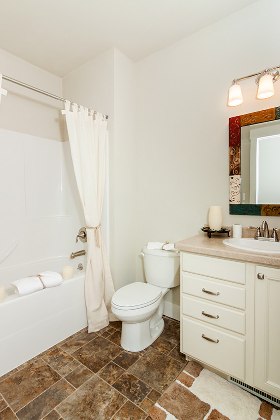 Corner bathtub - small transitional 3/4 ceramic tile corner bathtub idea with recessed-panel cabinets, white cabinets, a two-piece toilet, white walls, an undermount sink and quartzite countertops