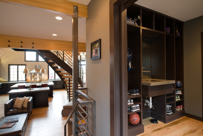 Example of a mid-sized medium tone wood floor vestibule design with brown walls