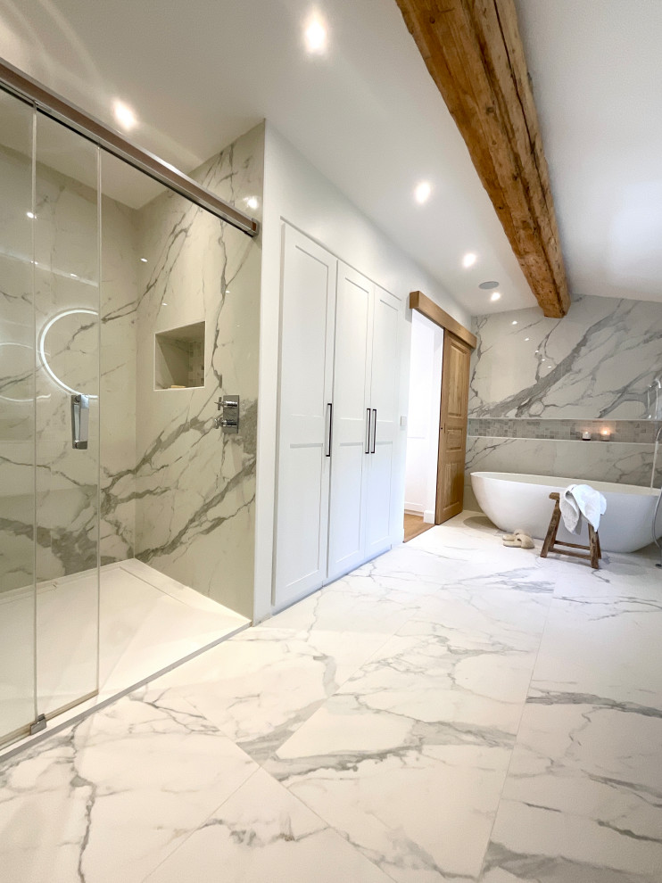 This is an example of a large mediterranean ensuite bathroom in Marseille with flat-panel cabinets, white cabinets, a built-in bath, a built-in shower, a two-piece toilet, grey tiles, marble tiles, white walls, marble flooring, a console sink, grey floors, a sliding door, white worktops, a single sink, a floating vanity unit and exposed beams.