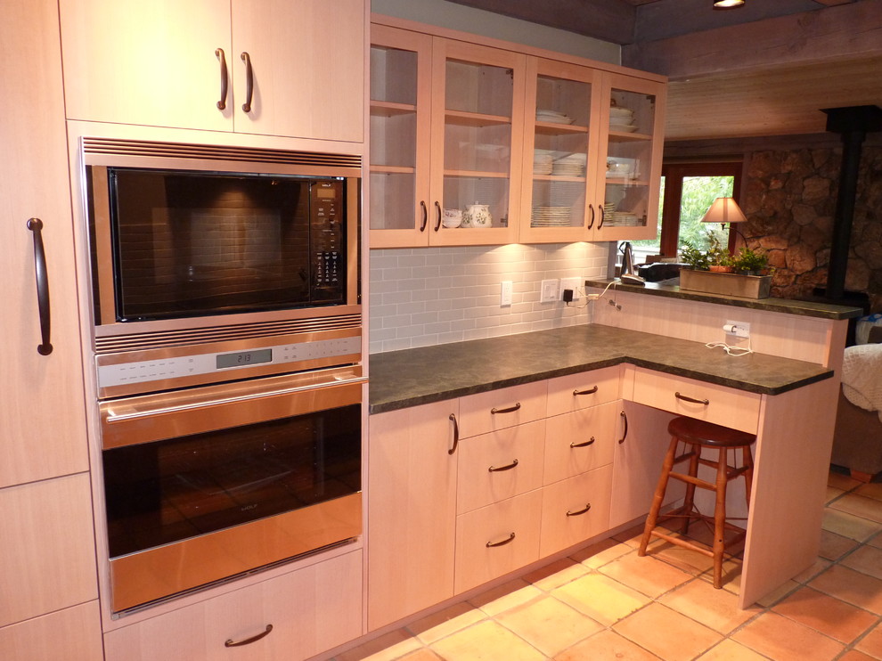Transitional galley eat-in kitchen photo in Seattle with an undermount sink, flat-panel cabinets, light wood cabinets, soapstone countertops, gray backsplash, porcelain backsplash and paneled appliances