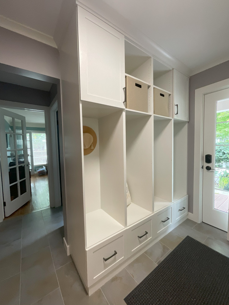 Photo of a small transitional mudroom in Detroit with beige walls, porcelain floors, a single front door, a white front door and brown floor.