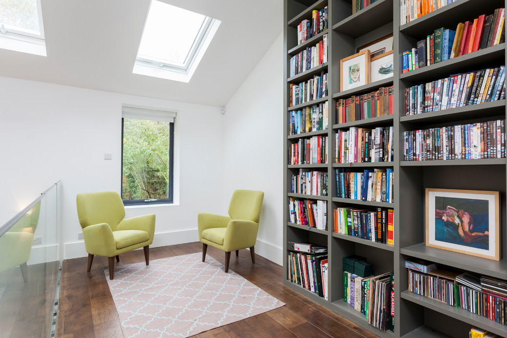 Design ideas for a contemporary home office in London with a library, white walls and dark hardwood floors.