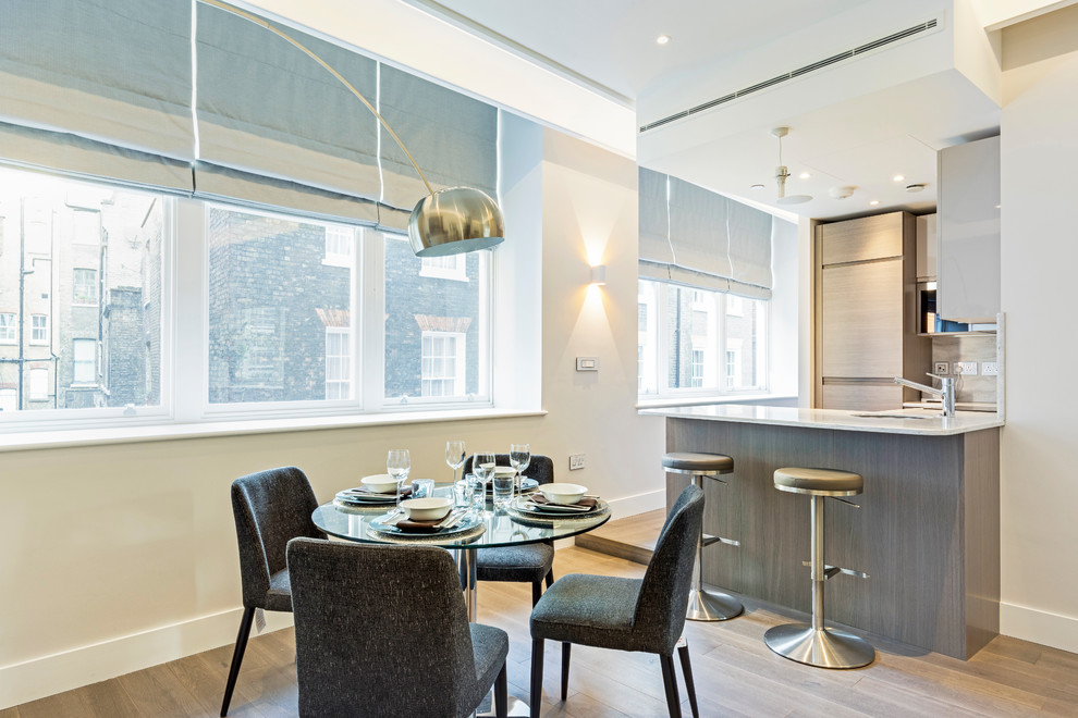 This is an example of a large contemporary open plan dining in London with beige walls, no fireplace, medium hardwood floors and beige floor.