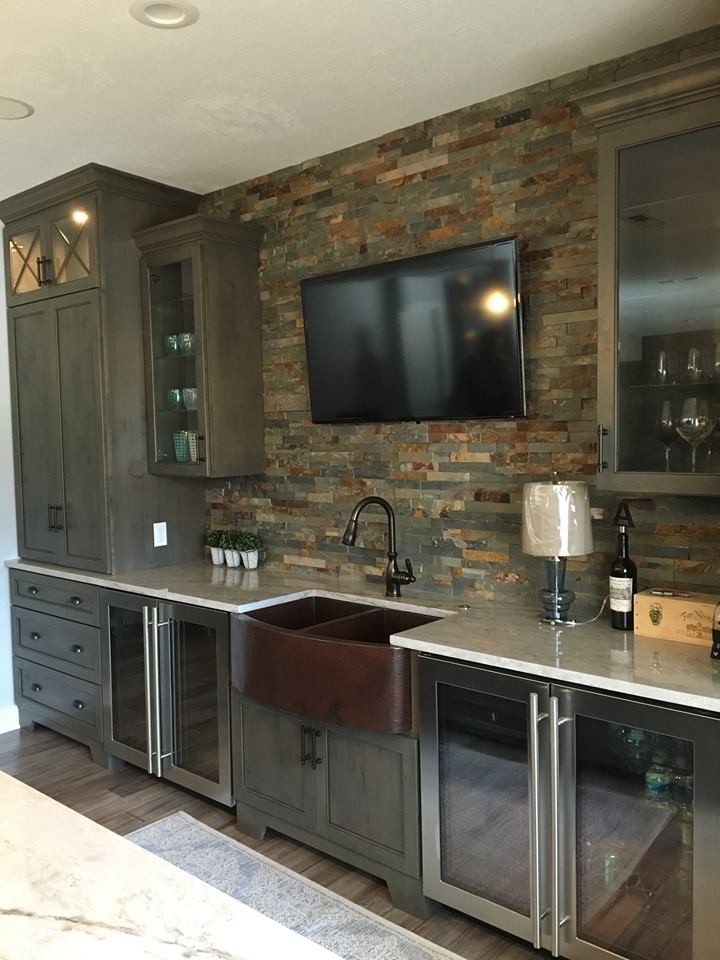 Photo of a country wet bar in Cleveland with an undermount sink, glass-front cabinets, dark wood cabinets, multi-coloured splashback, stone tile splashback, dark hardwood floors and marble benchtops.