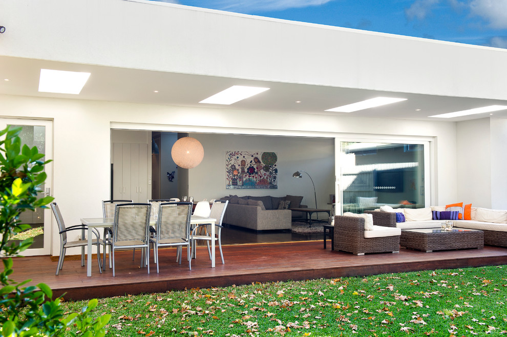 This is an example of a large contemporary backyard deck in Melbourne with an outdoor kitchen and a roof extension.