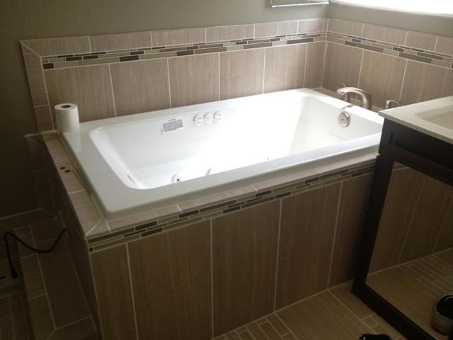 Photo of a mid-sized transitional master bathroom in San Francisco with a drop-in tub, beige tile and porcelain tile.