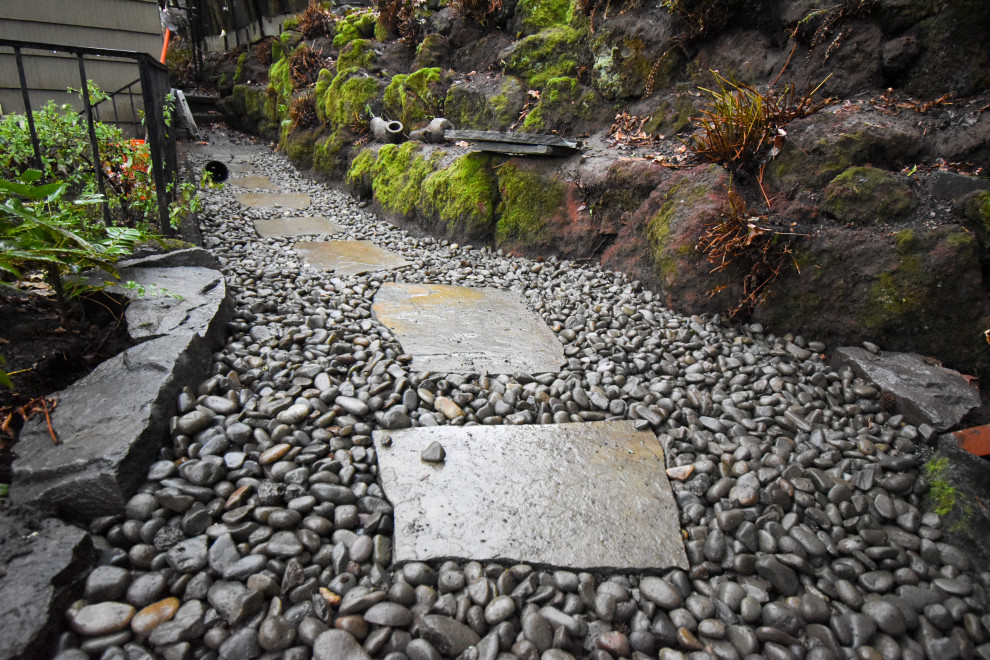 Inspiration pour un grand jardin arrière avec pierres et graviers, une exposition ombragée et des pavés en pierre naturelle.
