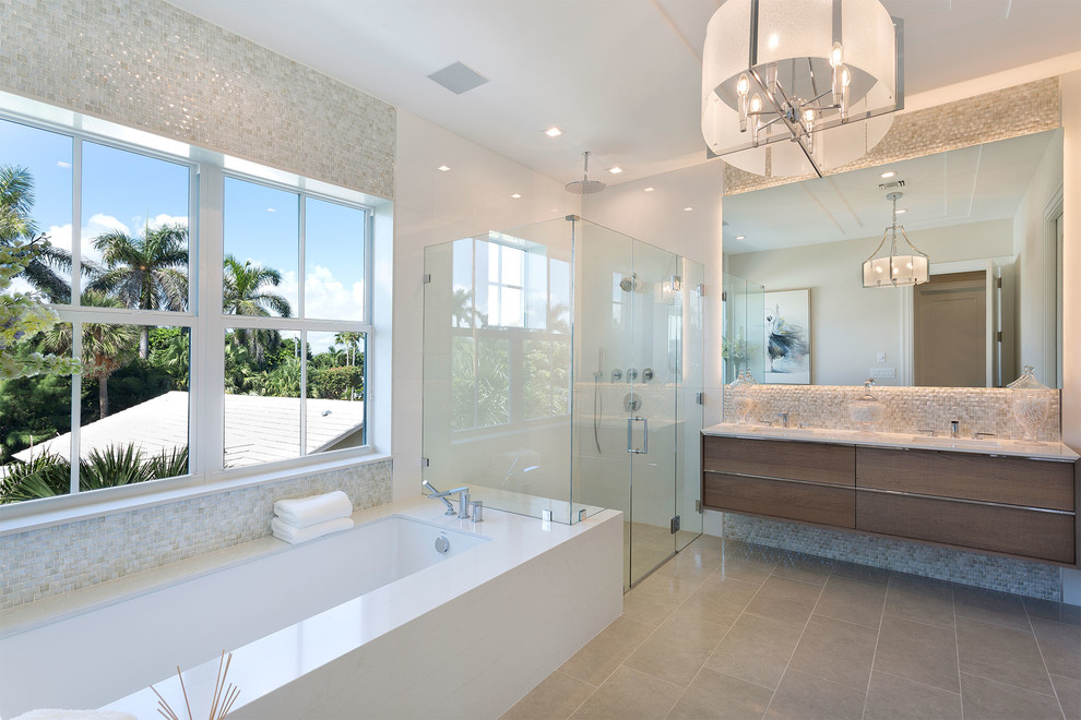 Large contemporary bathroom in Miami with brown cabinets, beige tile, a hinged shower door, an undermount tub, a corner shower, white walls, grey floor, a one-piece toilet, pebble tile, ceramic floors, an undermount sink, glass benchtops, beige benchtops and flat-panel cabinets.
