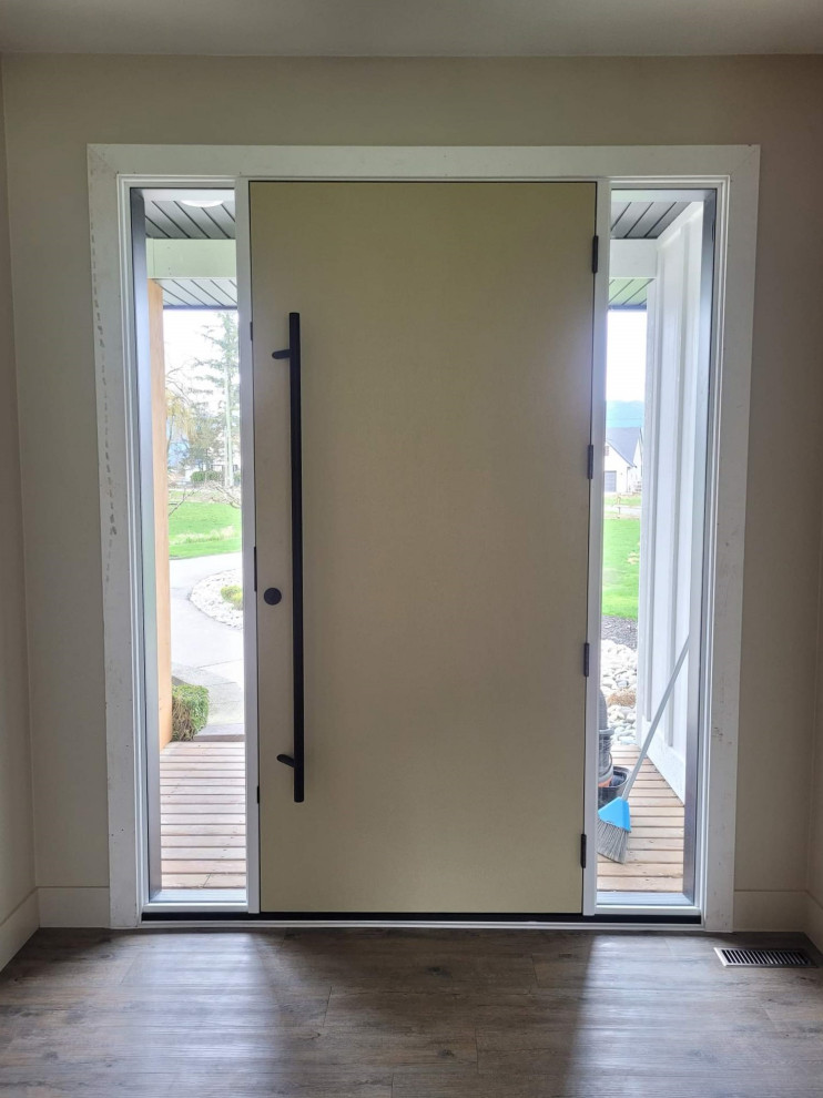 На фото: большая входная дверь в стиле модернизм с коричневыми стенами, паркетным полом среднего тона, одностворчатой входной дверью, желтой входной дверью и коричневым полом с