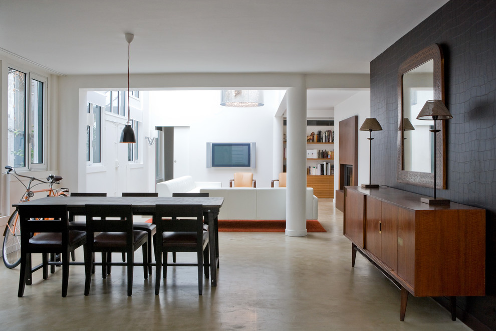 Large contemporary open plan dining in Paris with brown walls and concrete floors.