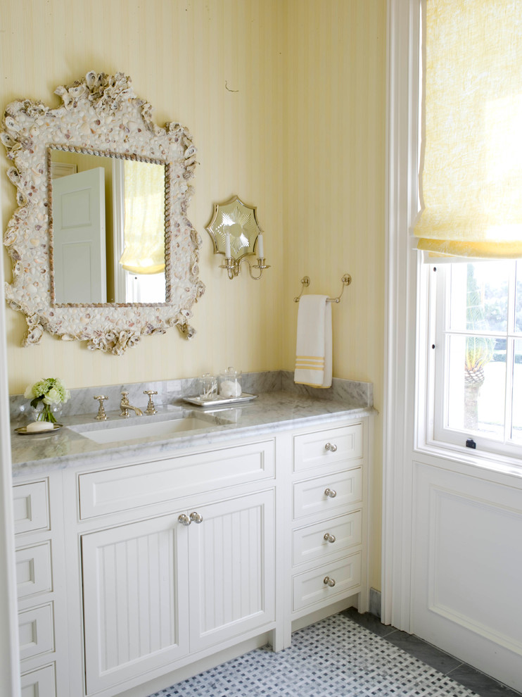 Inspiration for a large beach style bathroom in Jacksonville with white cabinets, yellow walls, an undermount sink, marble benchtops and beaded inset cabinets.