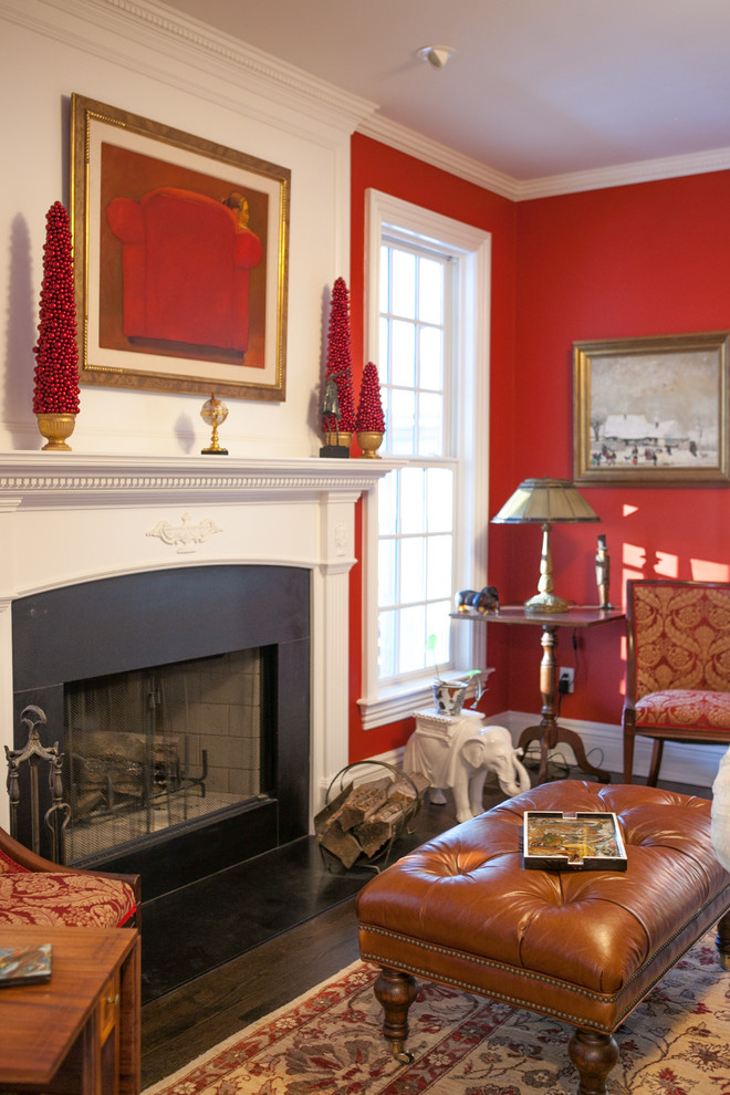 Photo of a mid-sized traditional enclosed living room in New York with red walls, dark hardwood floors and a standard fireplace.