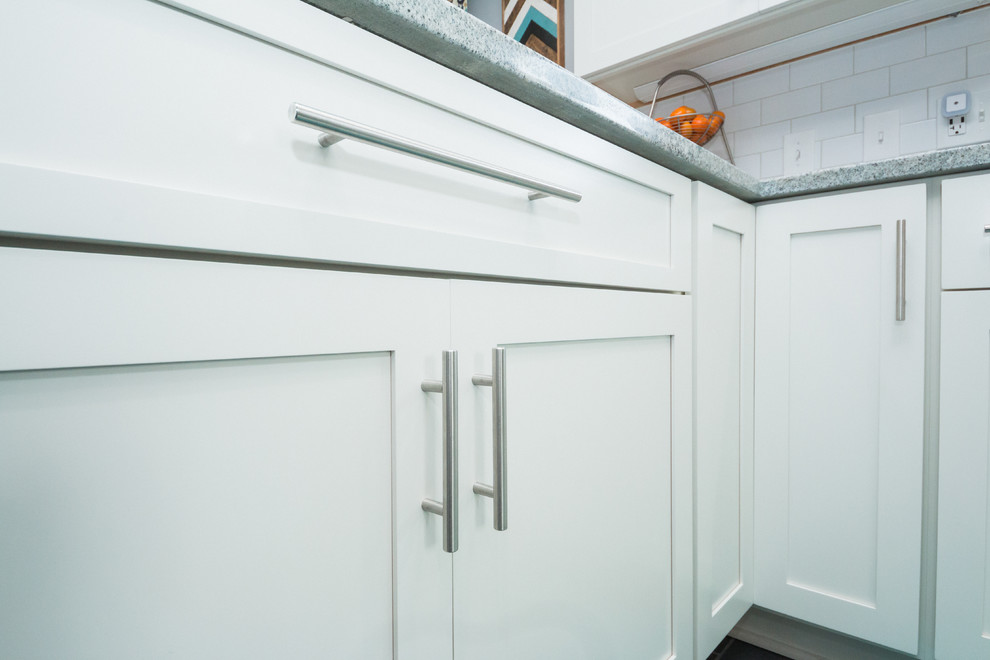Example of a mid-sized transitional l-shaped eat-in kitchen design in Columbus with an undermount sink, shaker cabinets, white cabinets, granite countertops, white backsplash, subway tile backsplash and stainless steel appliances