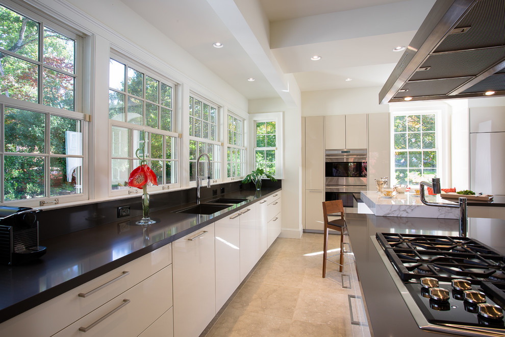 Inspiration for an expansive contemporary l-shaped separate kitchen in Atlanta with a double-bowl sink, flat-panel cabinets, beige cabinets, quartz benchtops, travertine floors, multiple islands and stainless steel appliances.
