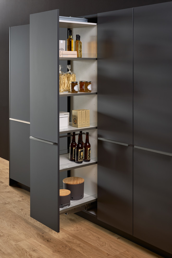 Large modern single-wall kitchen pantry in New York with a double-bowl sink, flat-panel cabinets, grey cabinets, solid surface benchtops, brown splashback, stainless steel appliances, concrete floors and with island.