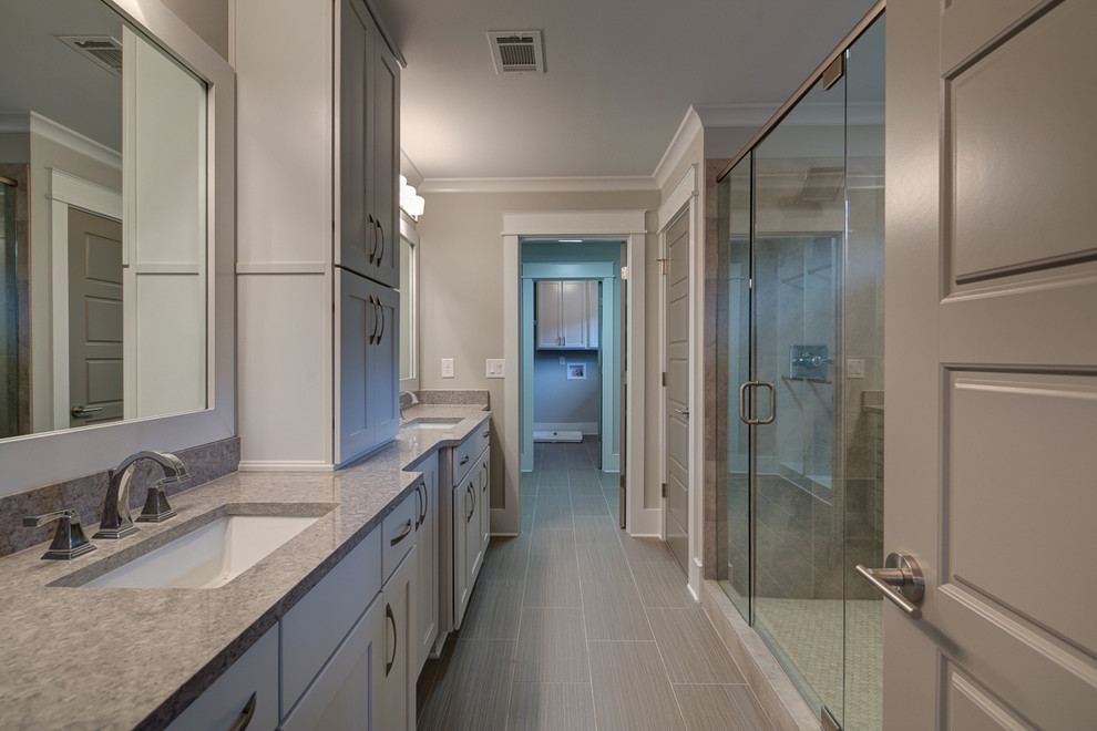 Mid-sized transitional 3/4 bathroom in Atlanta with recessed-panel cabinets, beige cabinets, an alcove tub, a two-piece toilet, gray tile, white tile, stone tile, beige walls, porcelain floors, an undermount sink, quartzite benchtops, an alcove shower, grey floor and a hinged shower door.