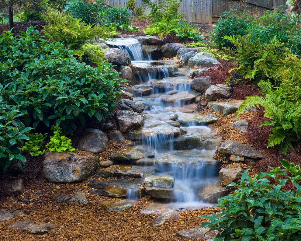 This is an example of a small traditional backyard partial sun formal garden for fall in Nashville with a water feature and natural stone pavers.