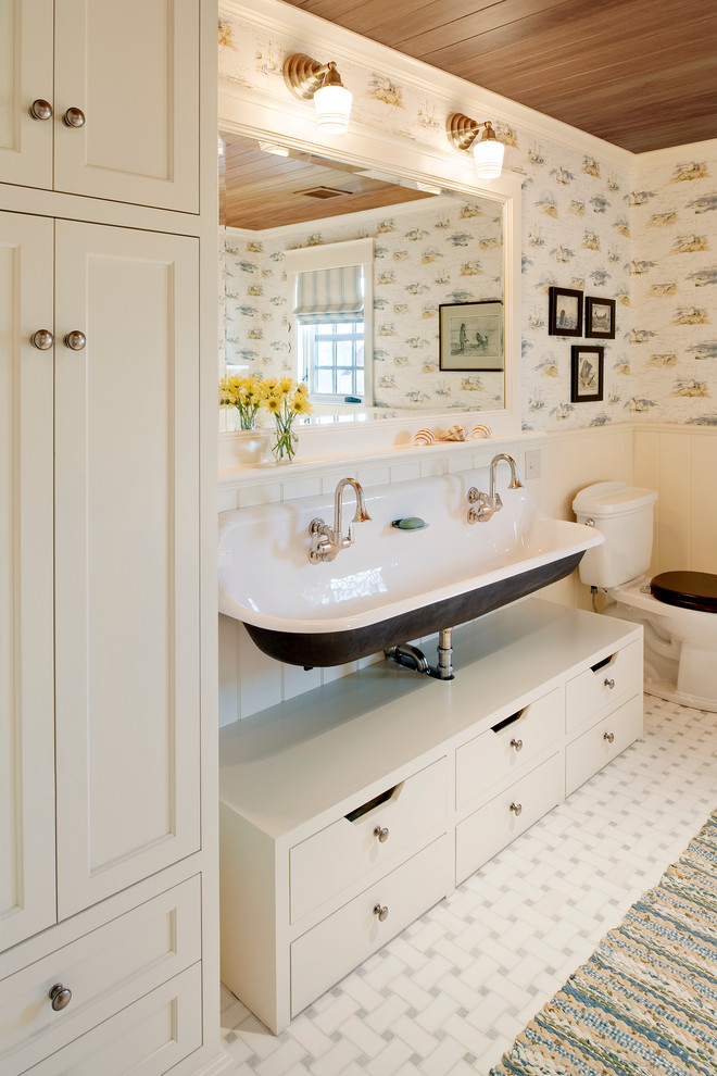 This is an example of a mid-sized beach style kids bathroom in Providence with a trough sink, flat-panel cabinets, white cabinets, a freestanding tub, a two-piece toilet, multi-coloured walls and ceramic floors.