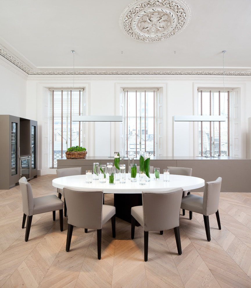 This is an example of a large contemporary dining room in Edinburgh with white walls and light hardwood floors.