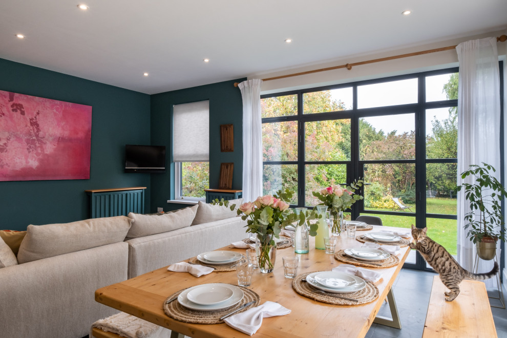 Large eclectic dining room in Gloucestershire with green walls, slate floors and green floor.