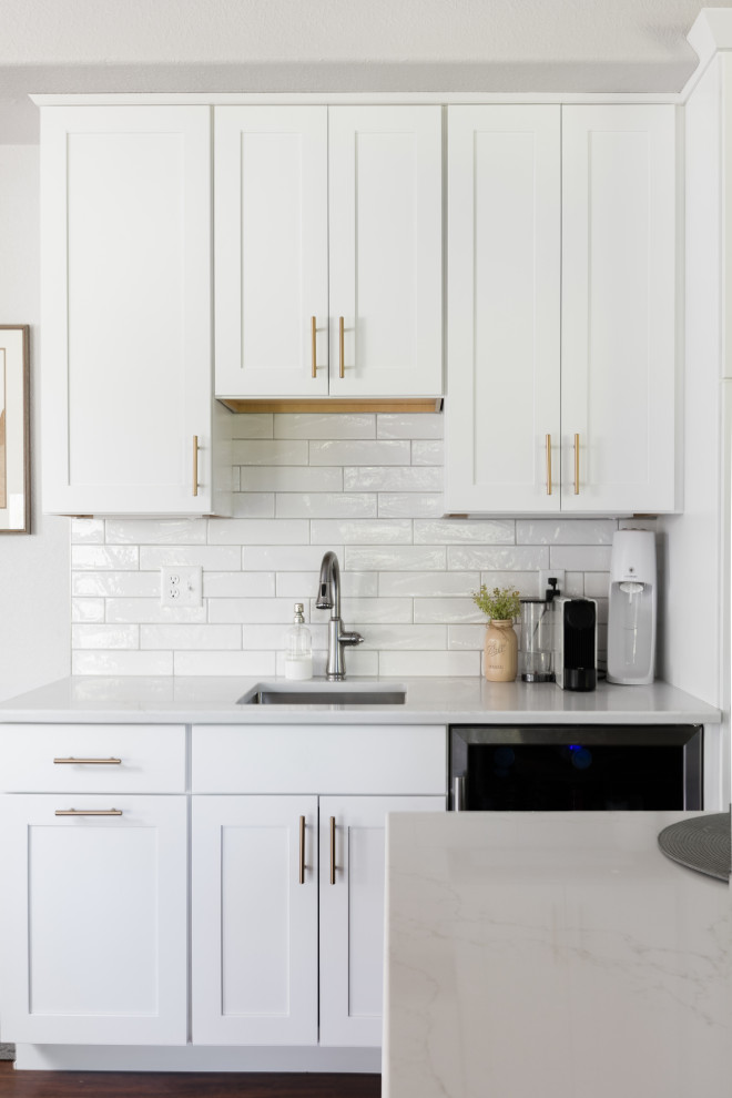 Eat-in kitchen - large transitional u-shaped dark wood floor eat-in kitchen idea in Denver with an undermount sink, shaker cabinets, white cabinets, quartz countertops, white backsplash, porcelain backsplash, stainless steel appliances, an island and white countertops