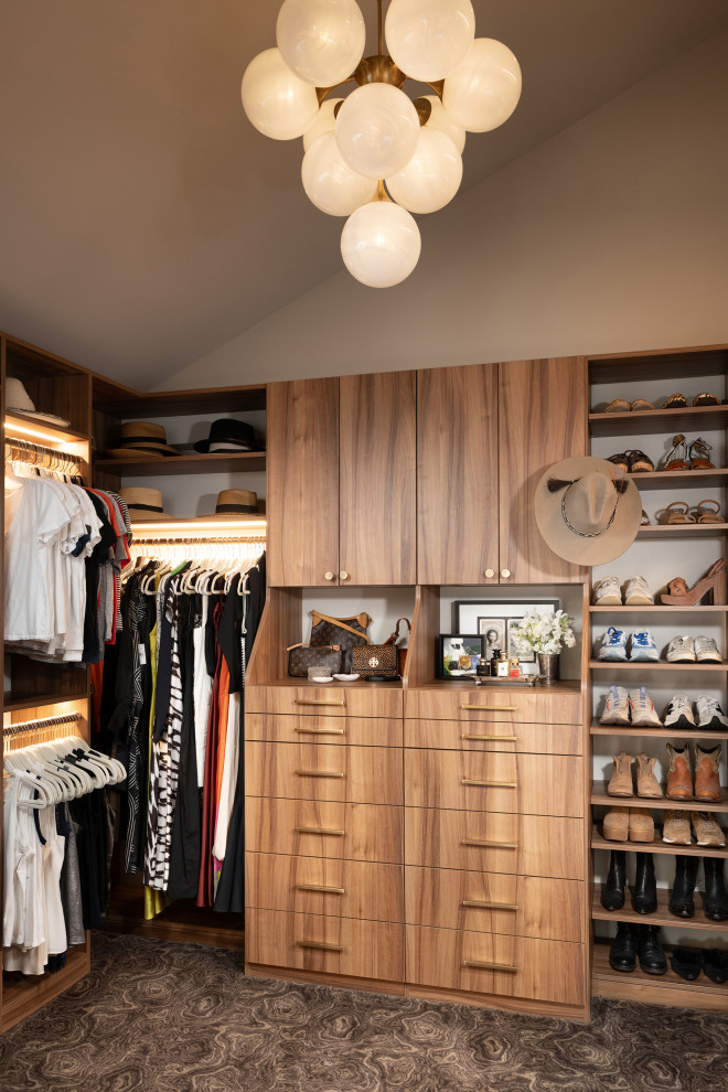 Mid-sized trendy women's carpeted, brown floor and vaulted ceiling walk-in closet photo in Other with flat-panel cabinets and medium tone wood cabinets