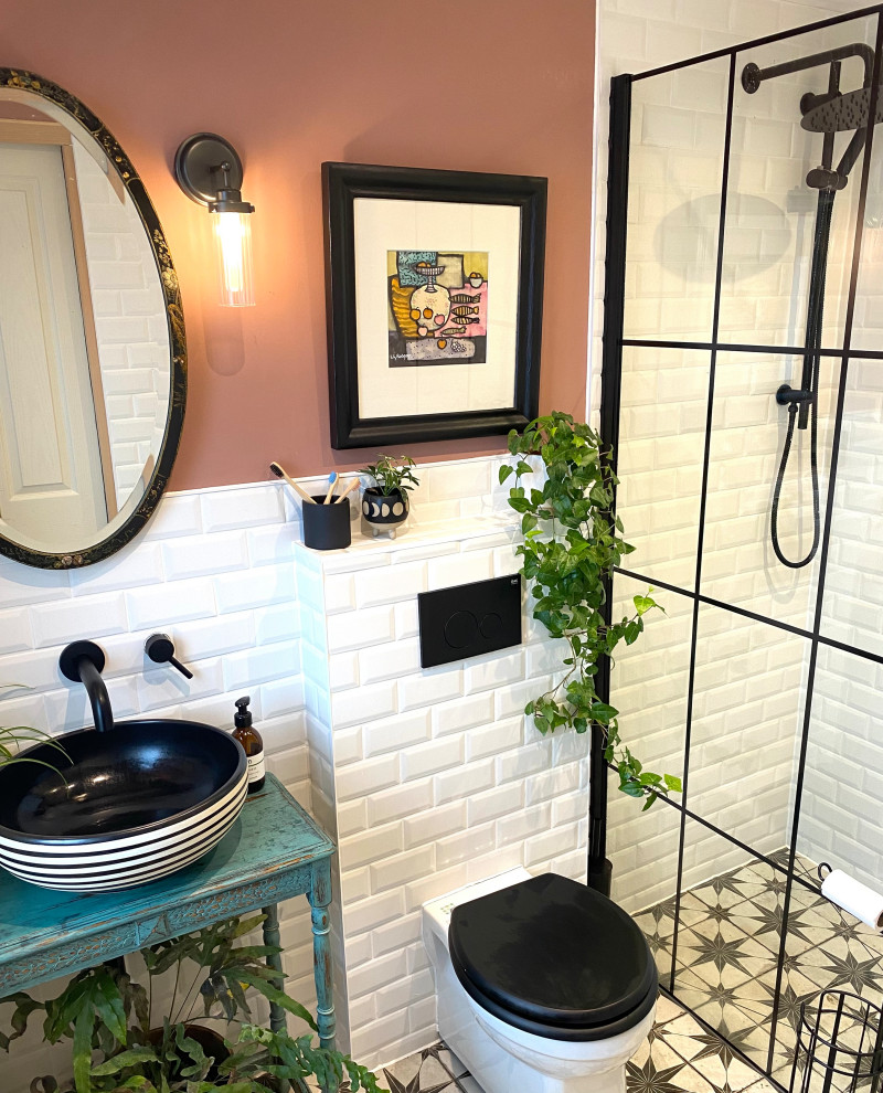 Design ideas for a mid-sized eclectic wet room bathroom in Essex with turquoise cabinets, a wall-mount toilet, white tile, ceramic tile, pink walls, porcelain floors, an open shower and a single vanity.
