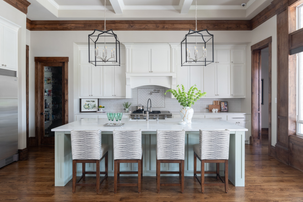 Example of a large transitional l-shaped dark wood floor and brown floor open concept kitchen design in Dallas with a farmhouse sink, shaker cabinets, white cabinets, marble countertops, white backsplash, subway tile backsplash, stainless steel appliances, an island and white countertops