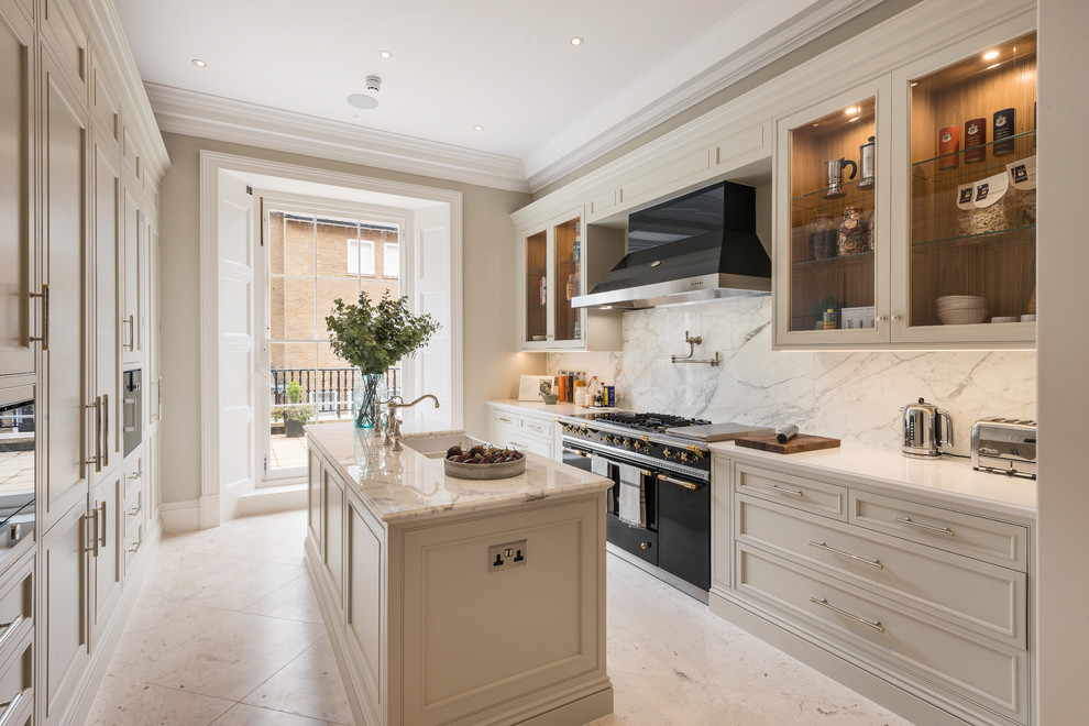 Mid-sized traditional galley kitchen in London with marble benchtops, white splashback, marble splashback, marble floors, with island, white floor, white benchtop, a farmhouse sink, recessed-panel cabinets, white cabinets and black appliances.