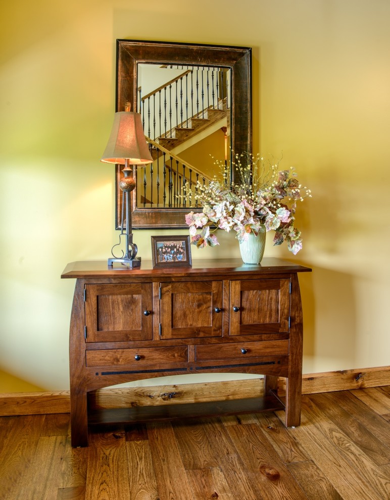 This is an example of a country foyer in Charleston with yellow walls, medium hardwood floors, a double front door and a medium wood front door.