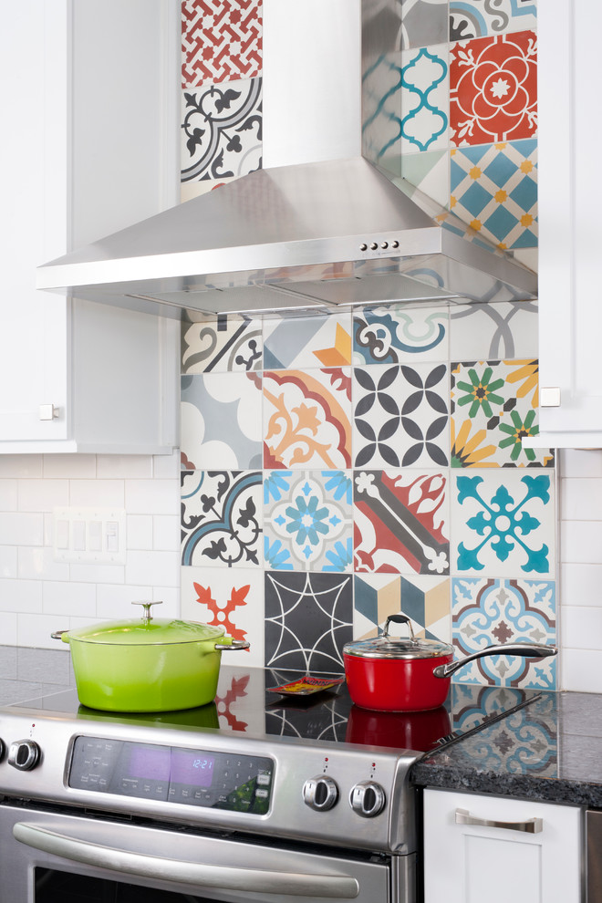 Inspiration for a mid-sized eclectic galley eat-in kitchen in DC Metro with an undermount sink, shaker cabinets, white cabinets, granite benchtops, multi-coloured splashback, cement tile splashback, stainless steel appliances and porcelain floors.