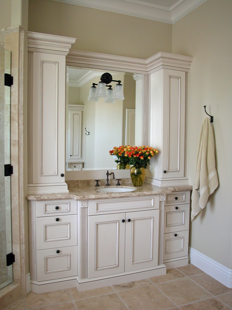 Design ideas for a large traditional master bathroom in San Luis Obispo with an undermount sink, recessed-panel cabinets, distressed cabinets, granite benchtops, beige walls and travertine floors.