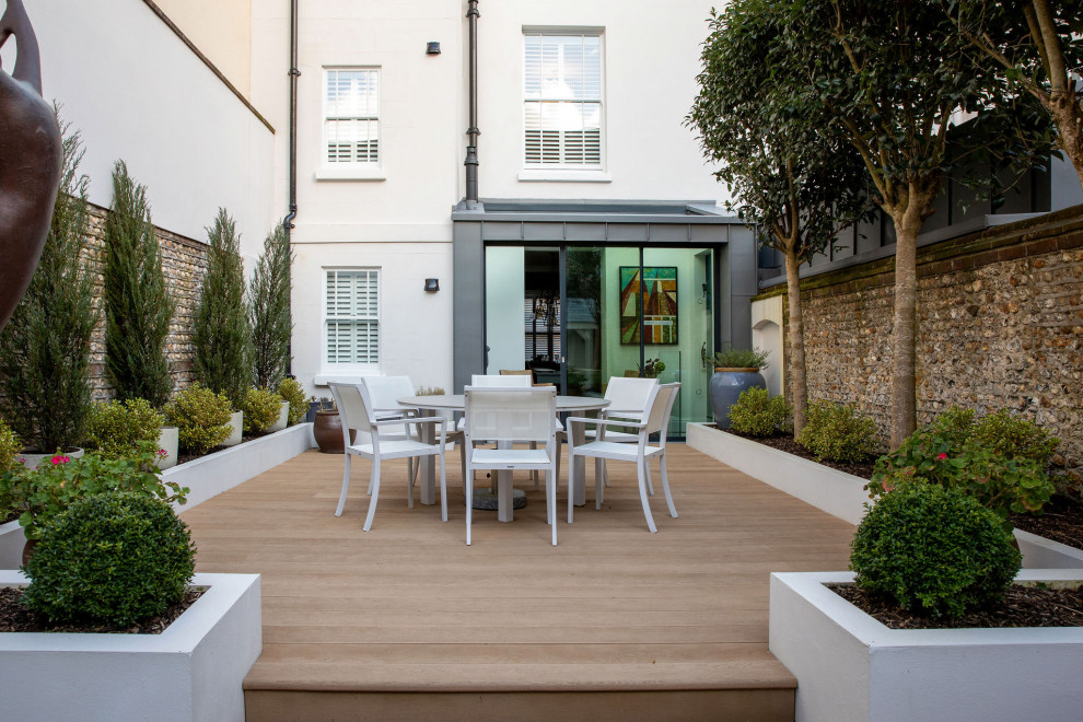 Unbedeckte Moderne Terrasse hinter dem Haus, im Erdgeschoss mit Kübelpflanzen in Sussex