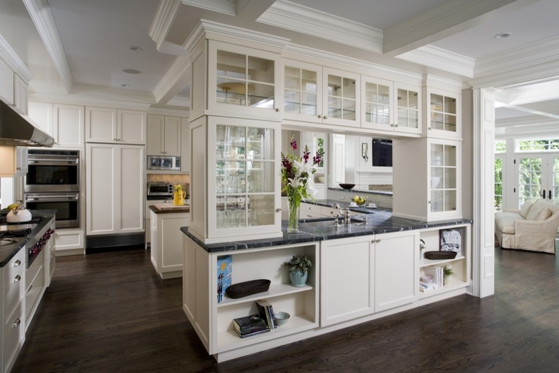 Inspiration for a mid-sized traditional u-shaped open plan kitchen in Chicago with a single-bowl sink, recessed-panel cabinets, white cabinets, soapstone benchtops, ceramic splashback, stainless steel appliances, dark hardwood floors, white splashback, multiple islands and brown floor.