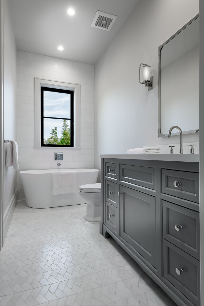 Inspiration for a mid-sized country kids bathroom in Los Angeles with raised-panel cabinets, grey cabinets, an alcove shower, a one-piece toilet, white walls, marble floors, a drop-in sink, marble benchtops, white floor, a hinged shower door, grey benchtops, a single vanity and a floating vanity.