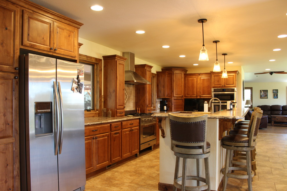 Large mountain style l-shaped ceramic tile and beige floor open concept kitchen photo in Denver with a drop-in sink, raised-panel cabinets, medium tone wood cabinets, laminate countertops, beige backsplash, ceramic backsplash, stainless steel appliances, an island and beige countertops