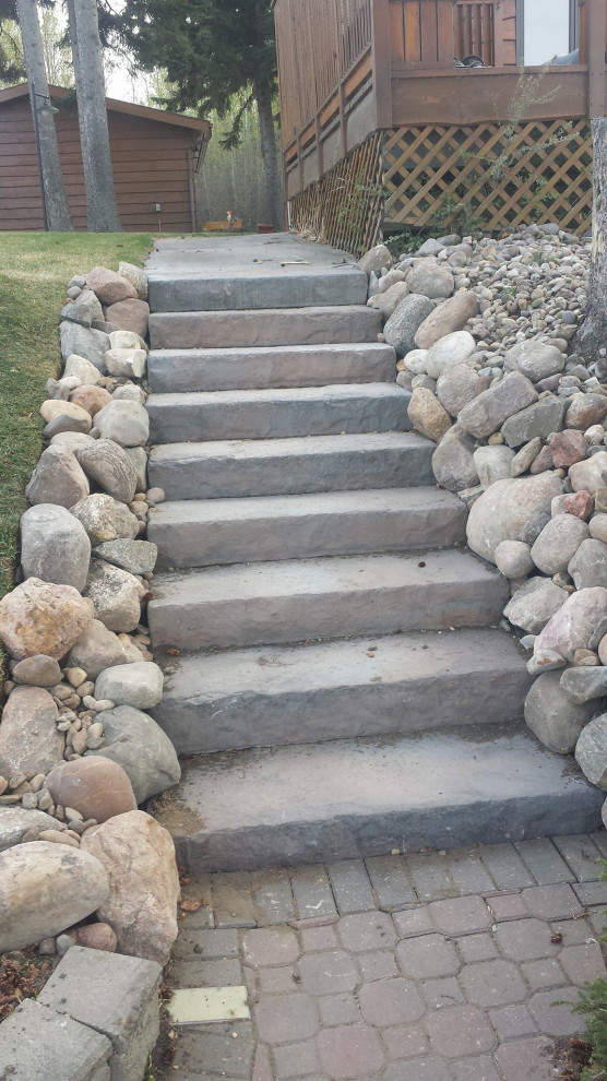 Photo of a mid-sized rustic partial sun backyard brick landscaping in Edmonton for summer.