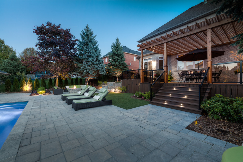 Inspiration for a large eclectic backyard brick patio remodel in Toronto with a fire pit and a pergola