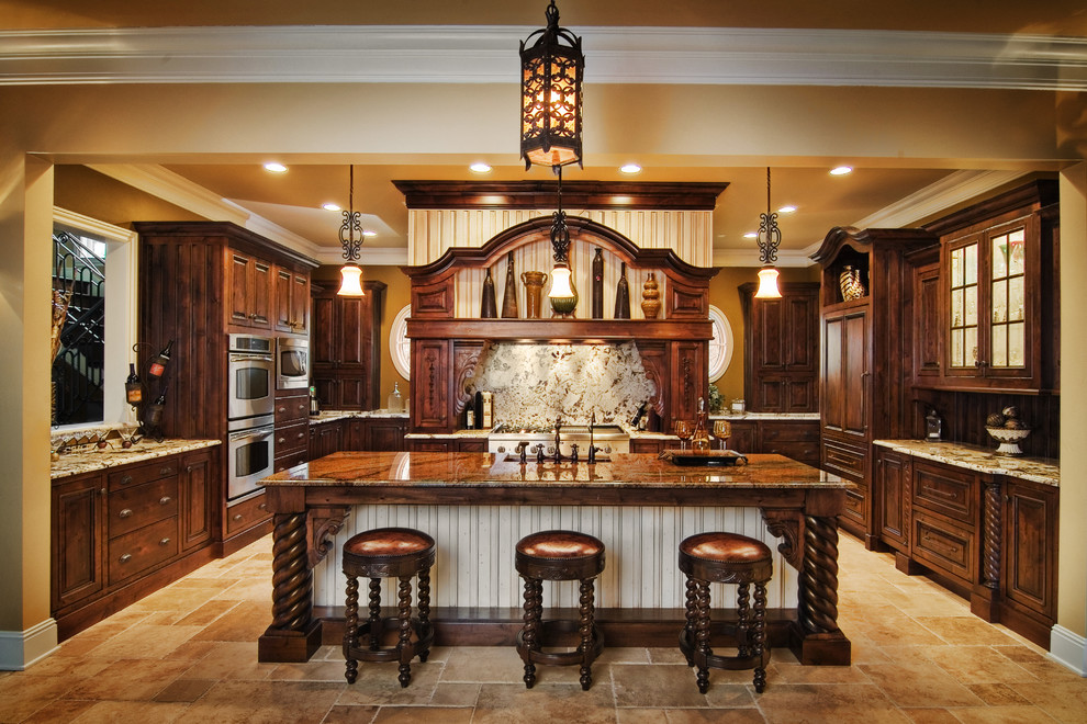 Inspiration for a large traditional u-shaped eat-in kitchen in Indianapolis with an undermount sink, recessed-panel cabinets, dark wood cabinets, granite benchtops, stone slab splashback, panelled appliances, travertine floors and with island.