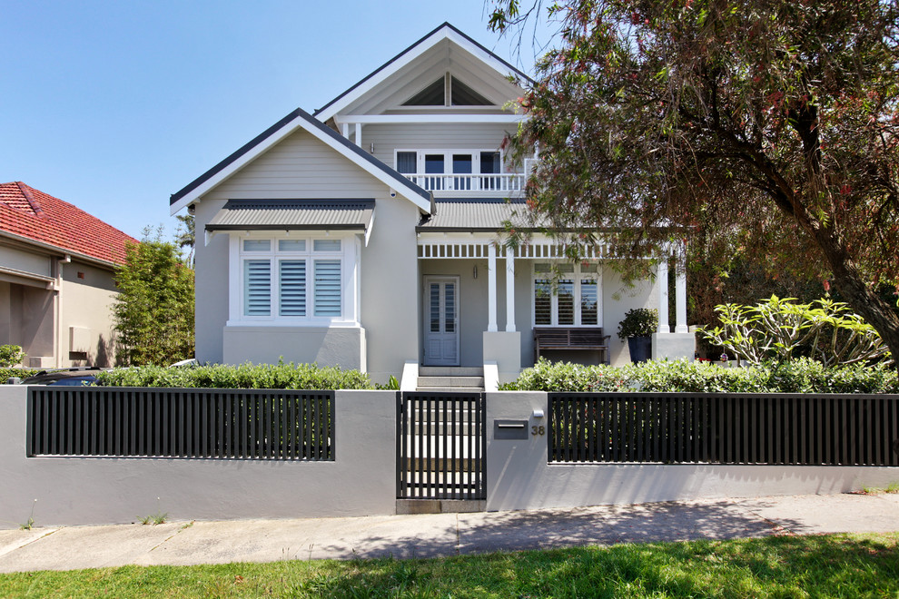 Inspiration for a mid-sized beach style two-storey beige exterior in Sydney with wood siding and a gable roof.