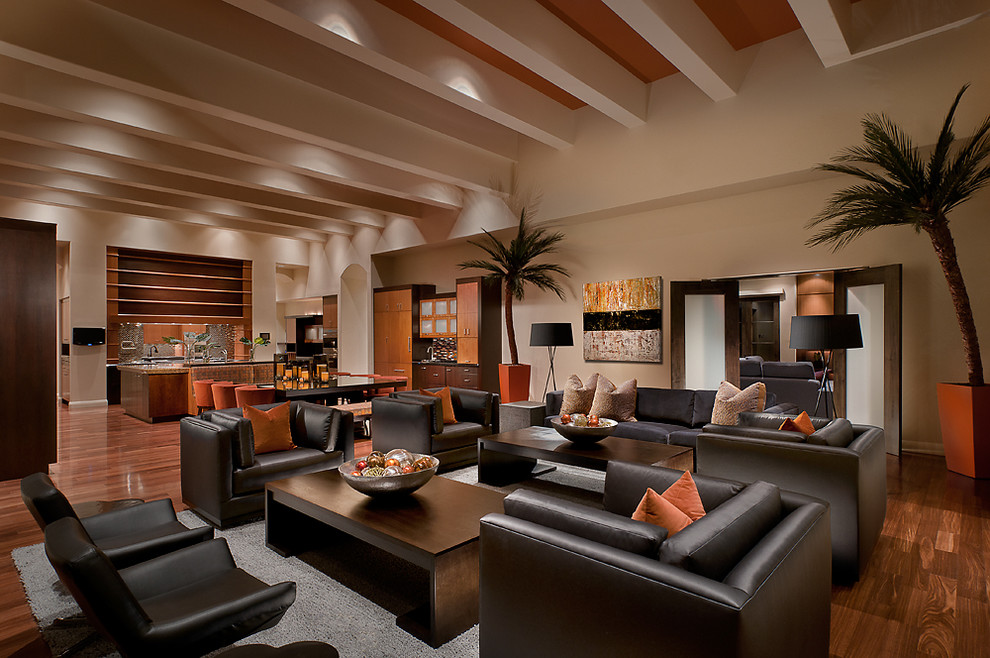 Inspiration for a tropical open concept family room in Phoenix with beige walls, medium hardwood floors and brown floor.