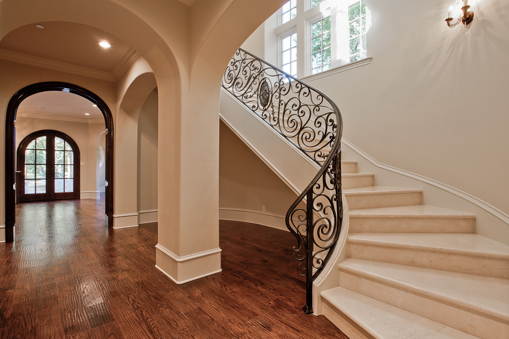 Inspiration for a large mediterranean marble curved staircase in Dallas with marble risers and metal railing.