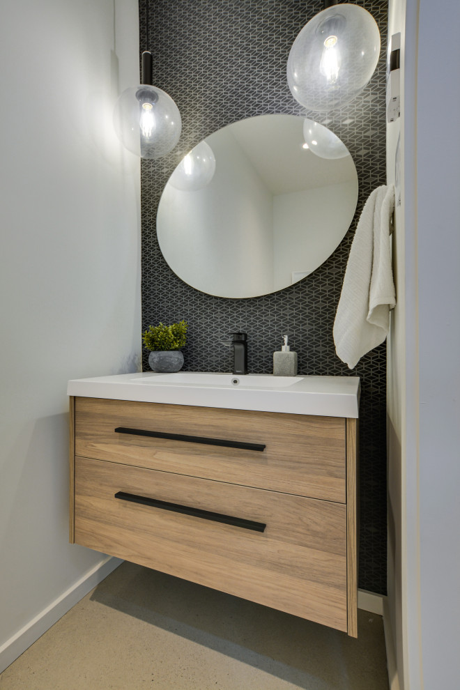 Cette image montre un petit WC et toilettes minimaliste en bois clair avec un placard à porte plane, un mur blanc, sol en béton ciré, un lavabo intégré, un sol gris, meuble-lavabo suspendu et du papier peint.