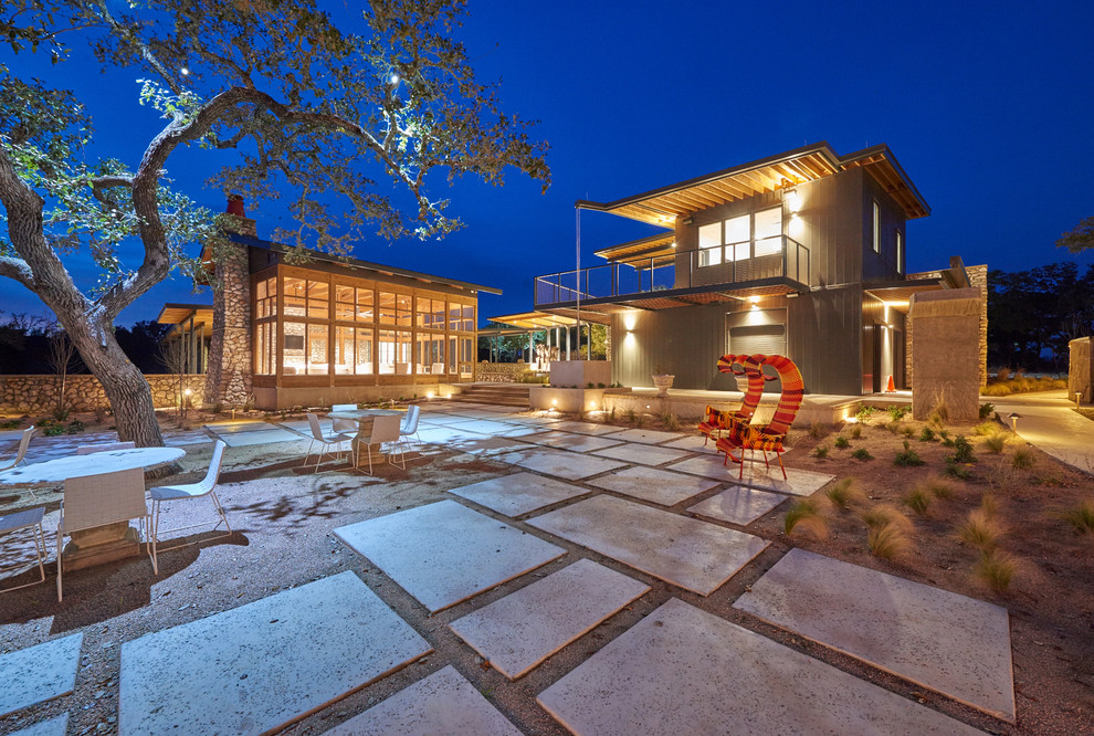 Photo of a large modern backyard partial sun garden in Austin with concrete pavers.