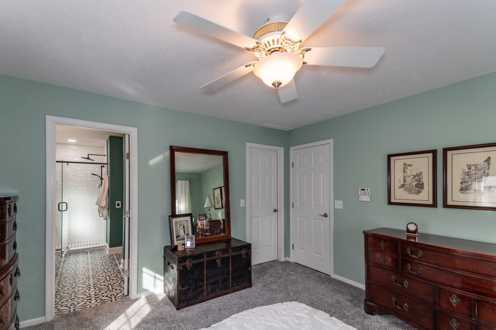 This is an example of a classic master bedroom in Cleveland with green walls, carpet and grey floors.