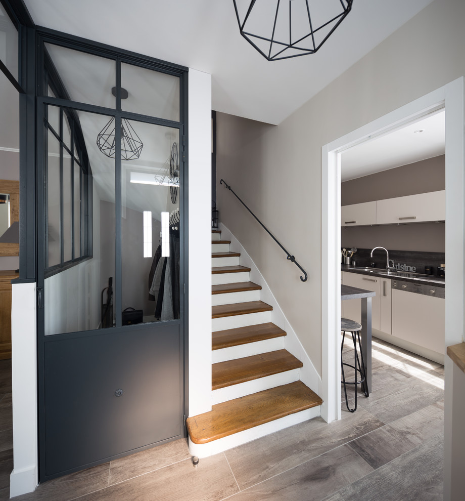 Design ideas for a mid-sized traditional foyer in Paris with grey walls, ceramic floors, a single front door, a black front door and grey floor.