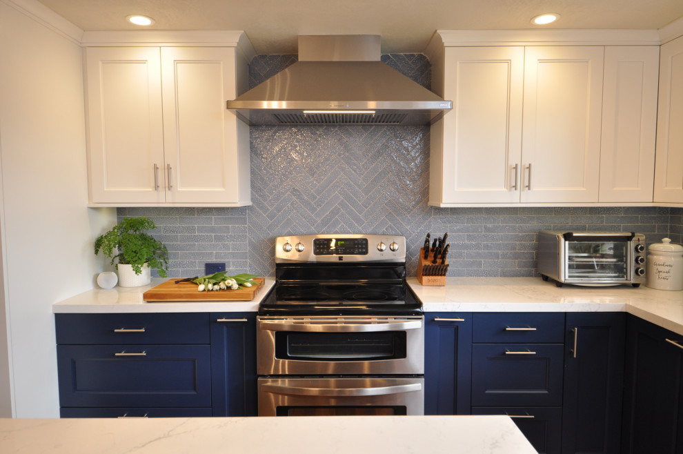 Exempel på ett avskilt, mellanstort klassiskt vit vitt u-kök, med en undermonterad diskho, skåp i shakerstil, vita skåp, bänkskiva i kvarts, blått stänkskydd, stänkskydd i tegel, rostfria vitvaror, laminatgolv, en köksö och brunt golv